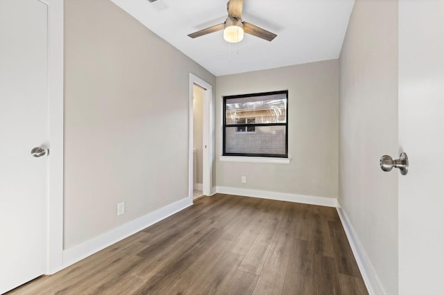 unfurnished room featuring baseboards, wood finished floors, and a ceiling fan
