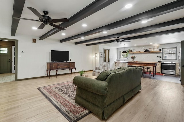 living area featuring light wood-style flooring, recessed lighting, baseboards, and beamed ceiling