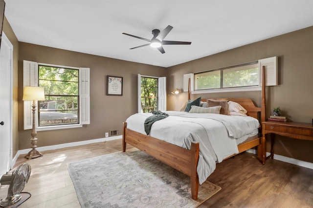 bedroom featuring a ceiling fan, baseboards, visible vents, and light wood finished floors