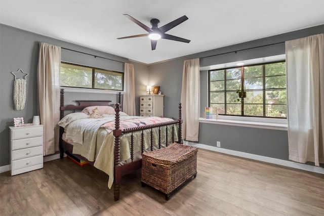 bedroom with wood finished floors, baseboards, and ceiling fan