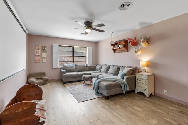 living room featuring visible vents, light wood-style flooring, baseboards, and a ceiling fan