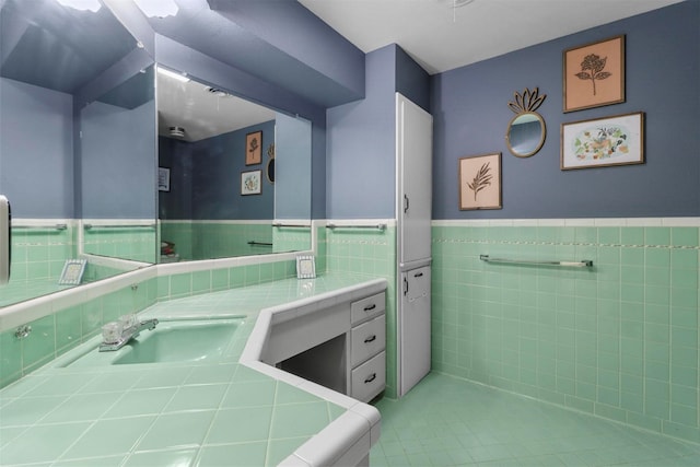 bathroom featuring a wainscoted wall, vanity, and tile walls