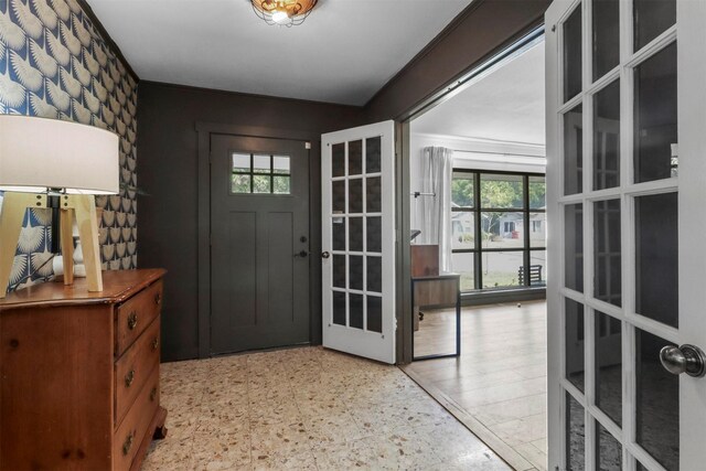 foyer featuring french doors, light floors, and a wealth of natural light