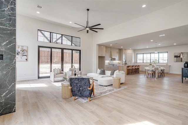 living area with recessed lighting, baseboards, light wood finished floors, and ceiling fan