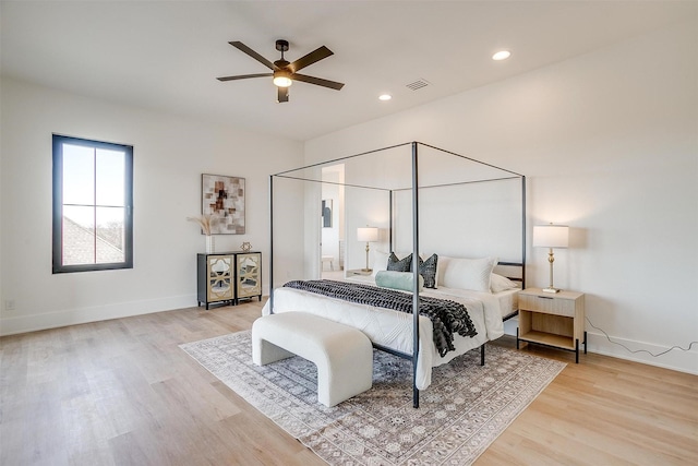 bedroom featuring light wood finished floors, visible vents, and baseboards