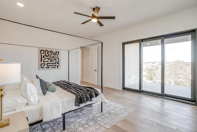 bedroom featuring baseboards, light wood-style floors, and access to outside