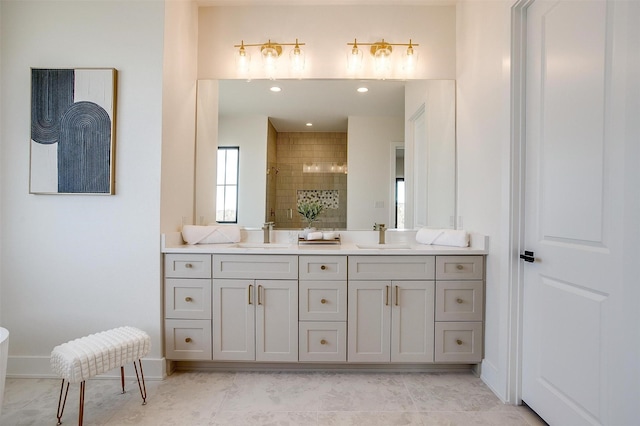 full bathroom featuring double vanity, baseboards, a stall shower, and a sink