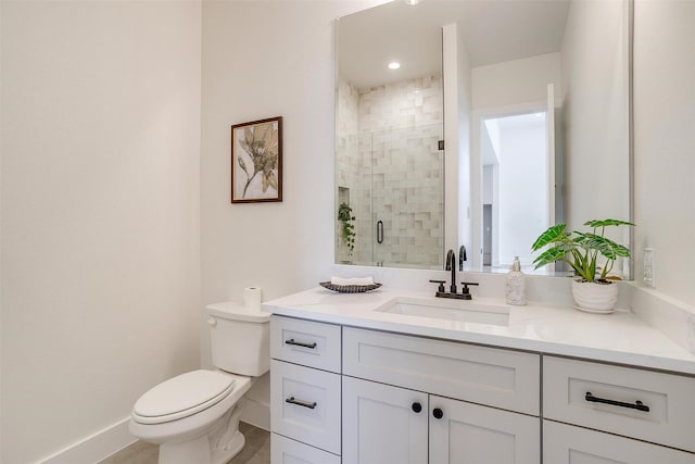 full bath featuring vanity, a shower stall, toilet, and baseboards