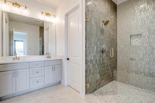 full bath featuring a sink, double vanity, a shower stall, and tile patterned floors