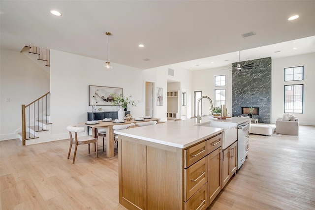 kitchen featuring light countertops, a ceiling fan, open floor plan, and light wood finished floors