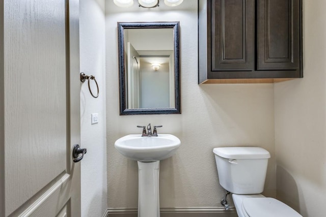 half bathroom featuring a sink and toilet