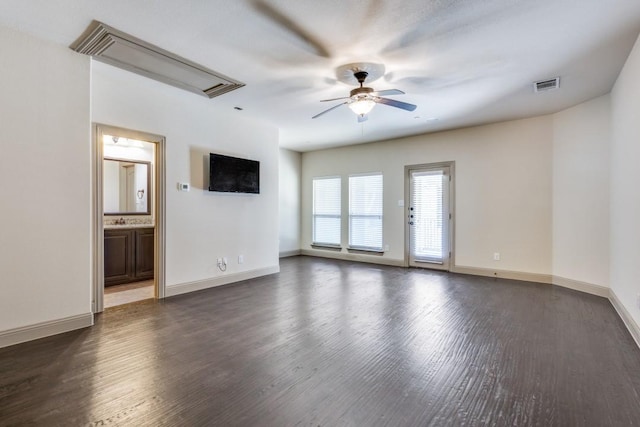 unfurnished living room featuring a ceiling fan, wood finished floors, visible vents, baseboards, and attic access