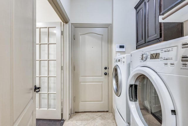 clothes washing area featuring light tile patterned floors, cabinet space, and separate washer and dryer