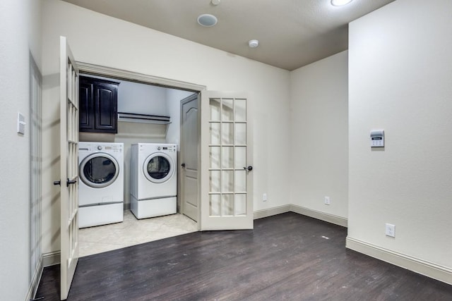 laundry area with cabinet space, independent washer and dryer, baseboards, and wood finished floors