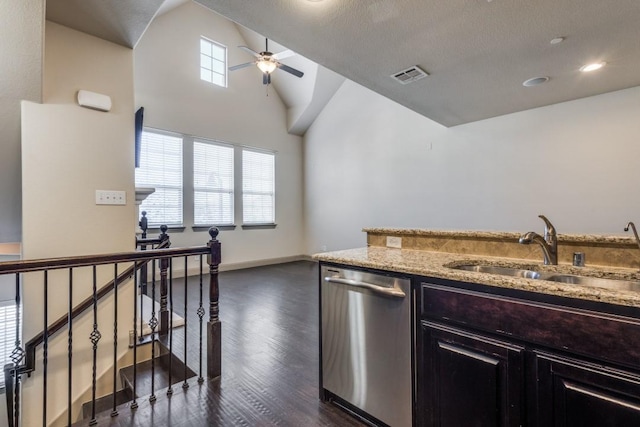 kitchen with light stone countertops, visible vents, dark wood finished floors, a sink, and dishwasher