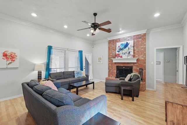 living room with a fireplace, baseboards, light wood finished floors, and ornamental molding