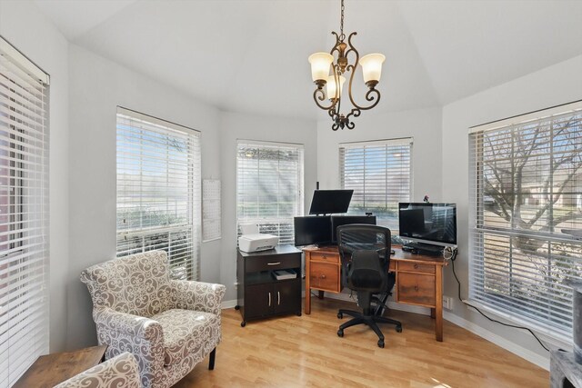 office space featuring baseboards, a chandelier, and light wood finished floors