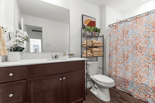 bathroom with visible vents, curtained shower, toilet, wood finished floors, and vanity