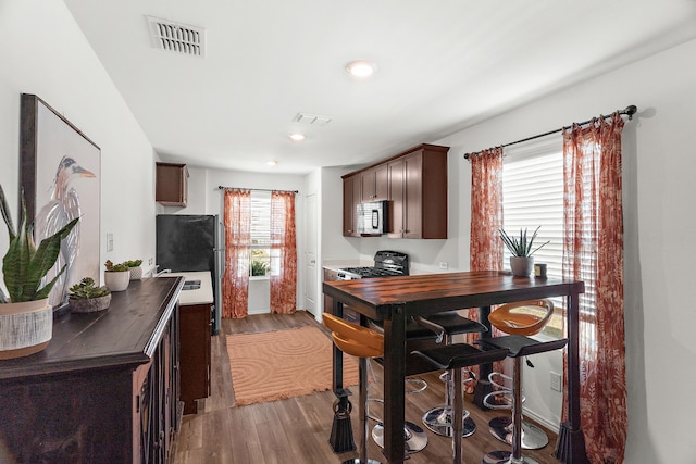 kitchen featuring visible vents, dark countertops, appliances with stainless steel finishes, and dark wood-style floors