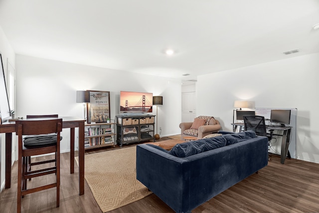 living area with visible vents, baseboards, and wood finished floors