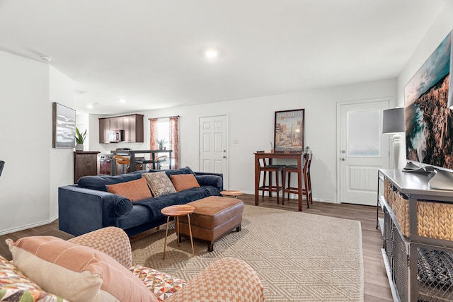 living room featuring light wood finished floors, recessed lighting, and baseboards