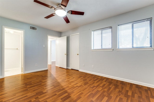 unfurnished bedroom featuring visible vents, baseboards, and wood finished floors