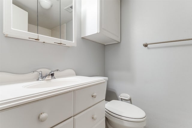 bathroom with vanity, toilet, and visible vents