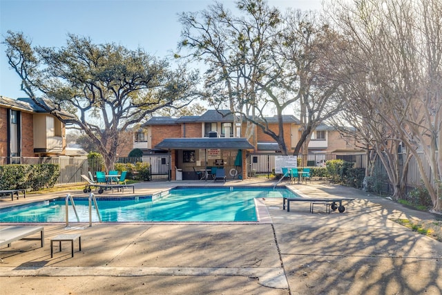 community pool featuring a patio area and fence