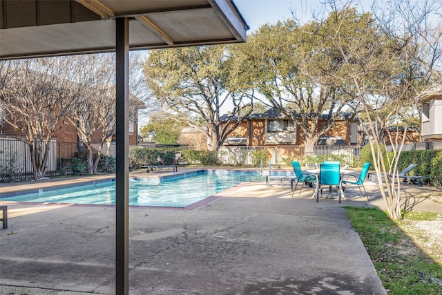 community pool with a patio and fence