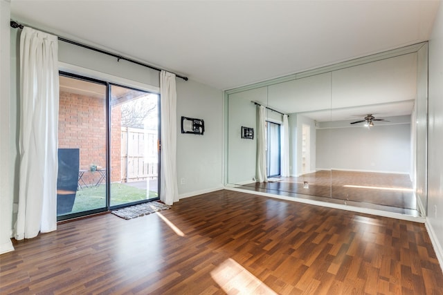 spare room featuring ceiling fan, baseboards, and wood finished floors