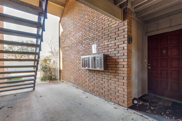 doorway to property with a garage and brick siding