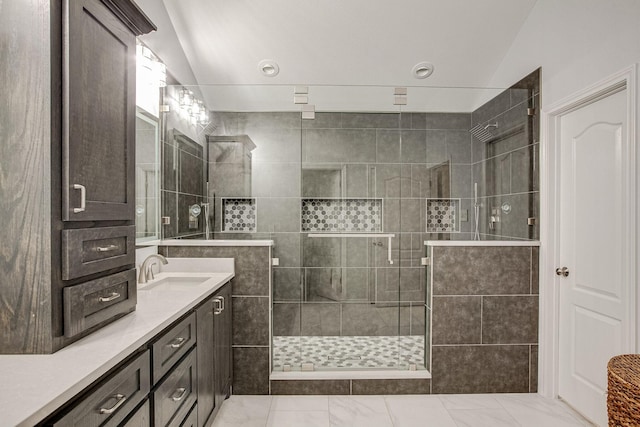 full bath featuring vanity, vaulted ceiling, and a tile shower