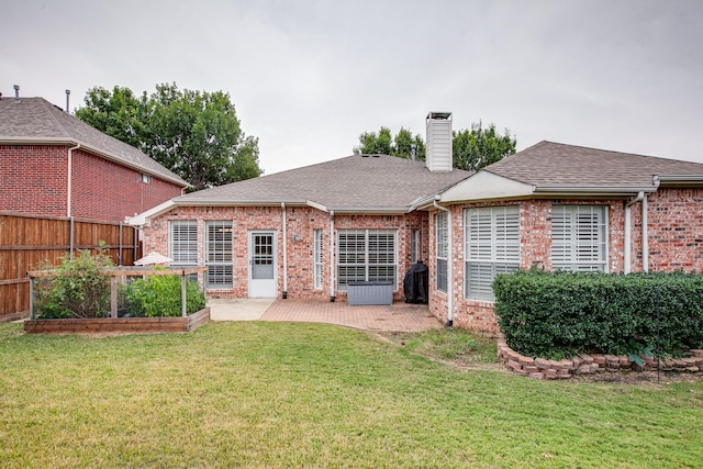 back of house featuring brick siding, a chimney, a vegetable garden, and fence