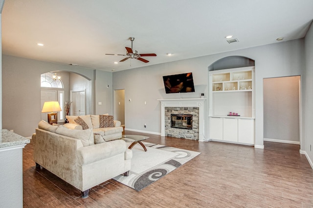 living area featuring visible vents, wood finished floors, recessed lighting, a stone fireplace, and baseboards