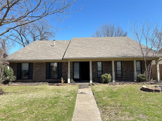 single story home featuring a front yard, brick siding, and roof with shingles