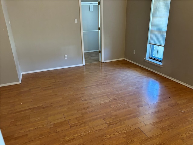 spare room featuring wood finished floors and baseboards