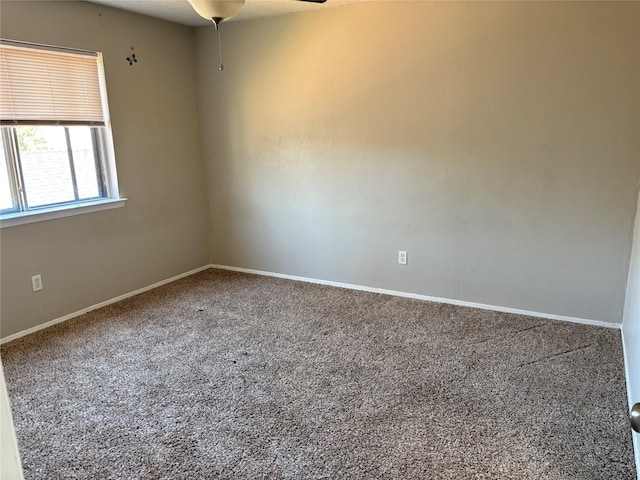 empty room with ceiling fan, baseboards, and carpet floors