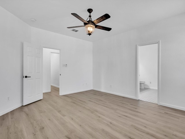 unfurnished bedroom with connected bathroom, visible vents, baseboards, and light wood-style flooring