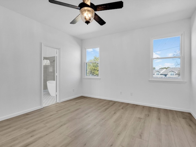 unfurnished bedroom with light wood-style flooring, ensuite bath, baseboards, and ceiling fan