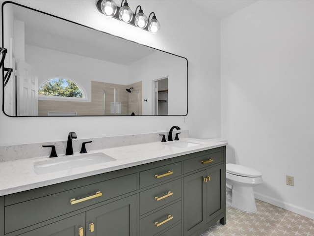 bathroom featuring double vanity, a shower stall, toilet, and a sink