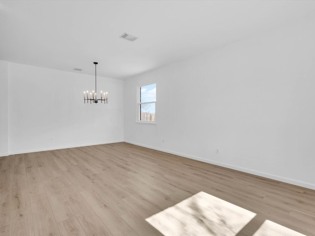 unfurnished dining area with visible vents, baseboards, light wood-style floors, and a chandelier