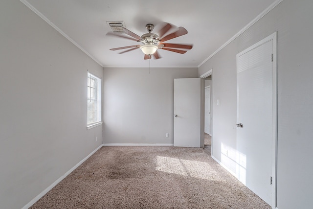 carpeted empty room featuring visible vents, a ceiling fan, baseboards, and ornamental molding