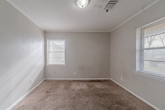 carpeted empty room featuring baseboards, visible vents, a wealth of natural light, and ornamental molding