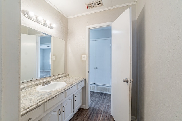 bathroom with visible vents, vanity, wood finished floors, and crown molding