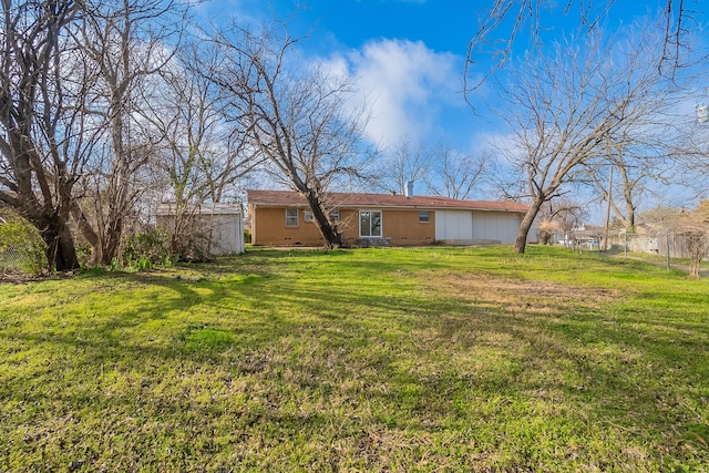 back of property featuring a yard and fence