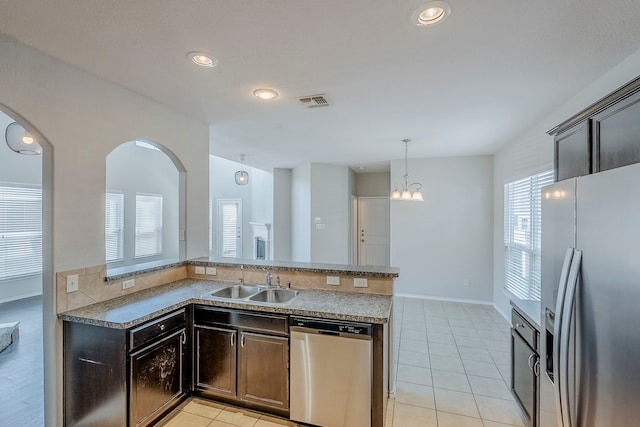 kitchen with light tile patterned floors, visible vents, a sink, stainless steel appliances, and pendant lighting