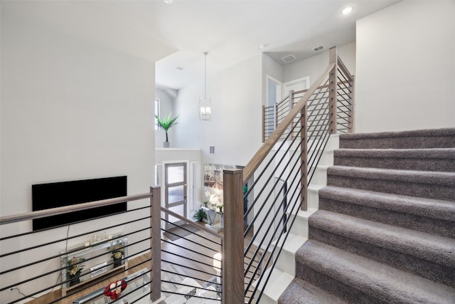 stairway featuring recessed lighting, visible vents, and an inviting chandelier