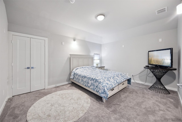 carpeted bedroom featuring baseboards, visible vents, and a closet