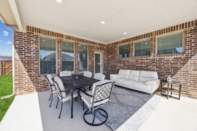 view of patio / terrace with outdoor dining space, fence, and an outdoor hangout area