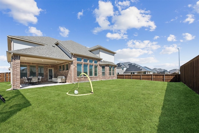 back of property featuring a patio area, brick siding, and a fenced backyard